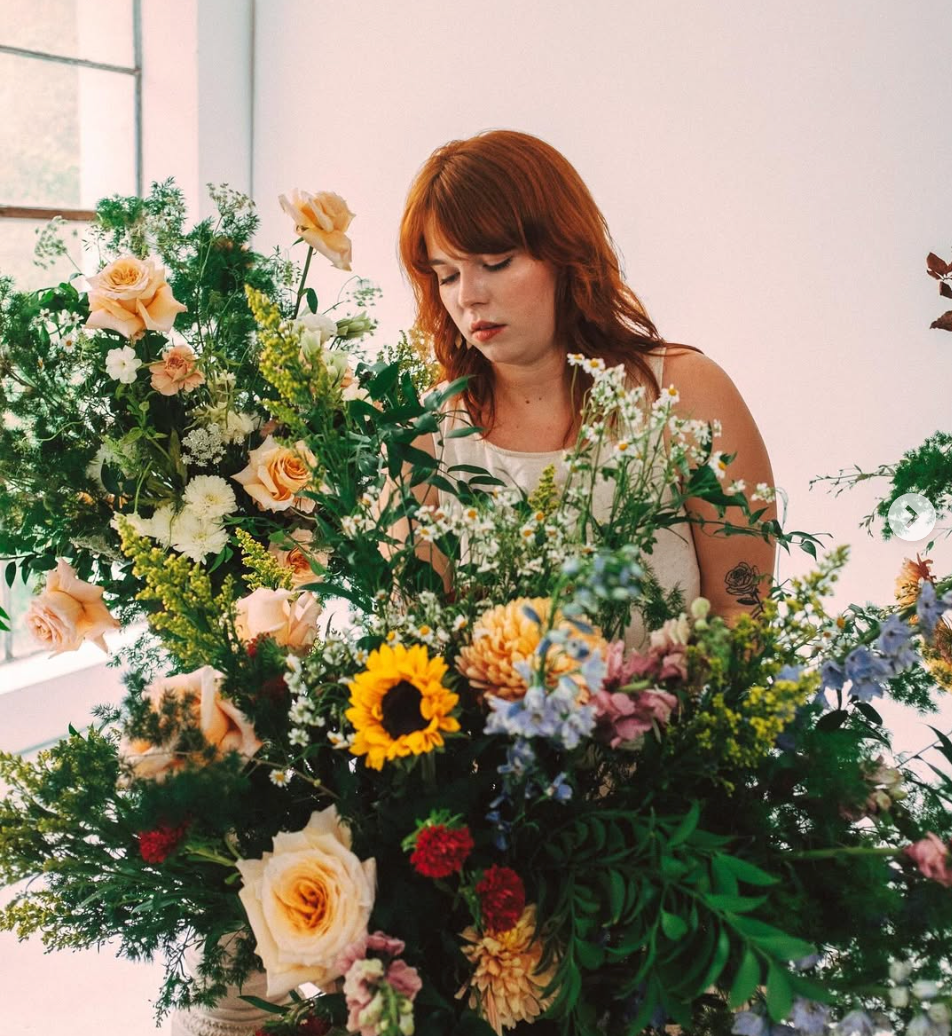 Woman arranging vibrant flowers in spa, St. Pete Florida.